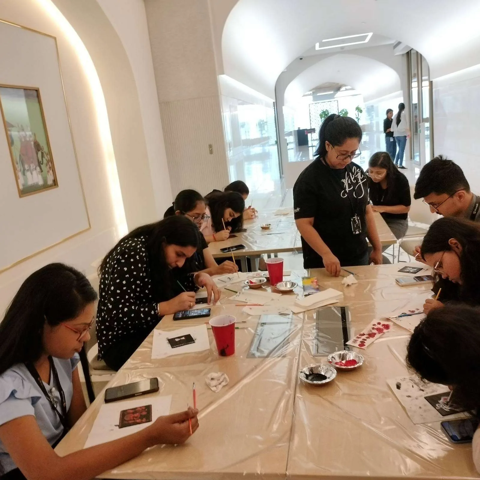 Workshop tables with participants painting coasters