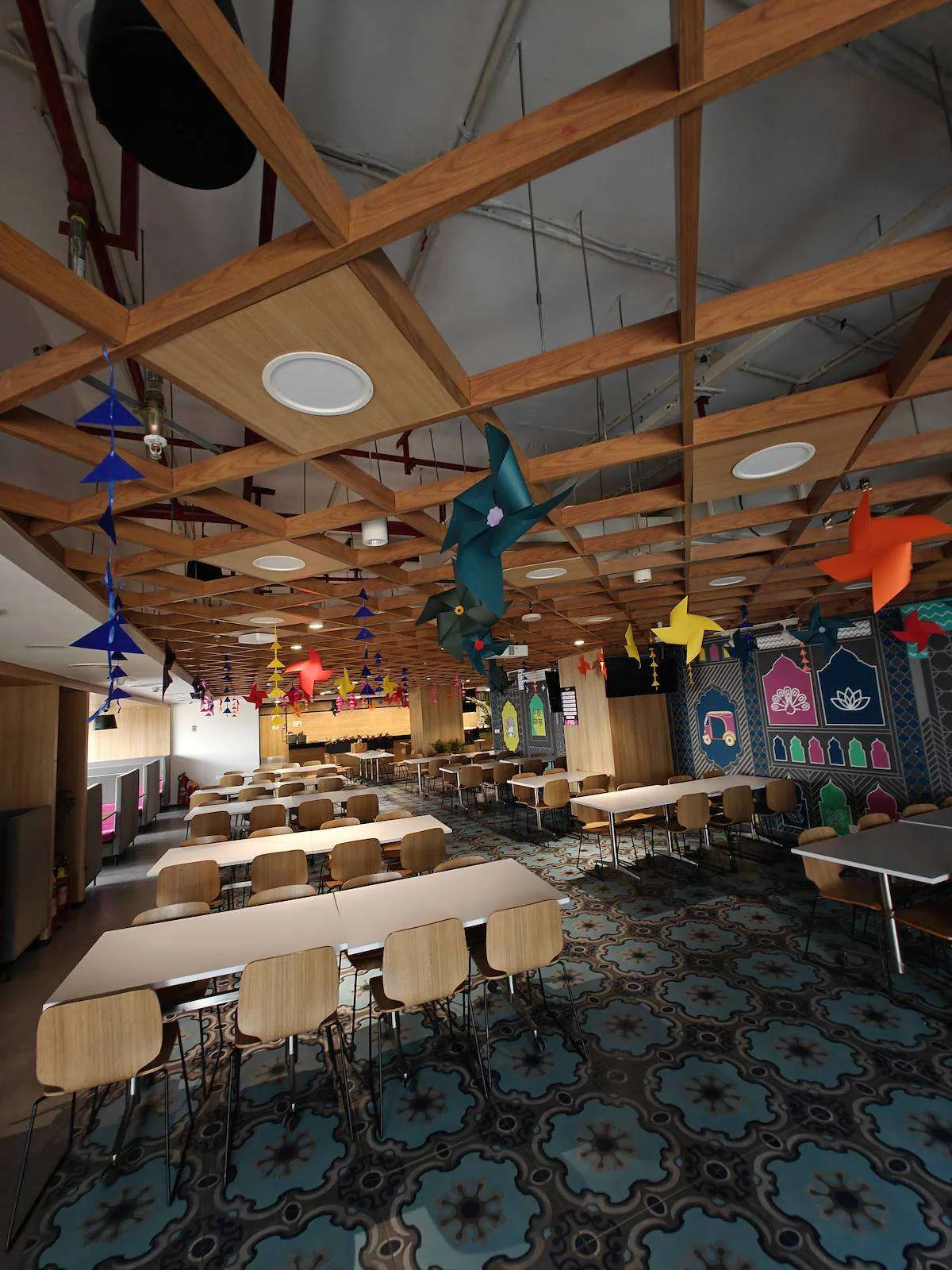Origami pinwheels hanging from a wooden ceiling grid