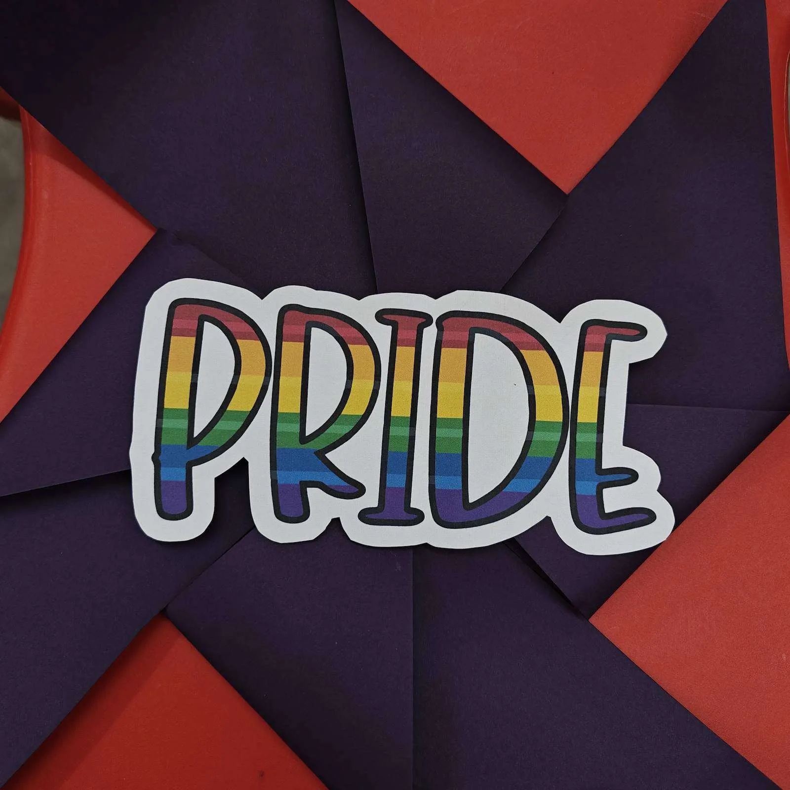 PRIDE sticker on a handmade origami pinwheel