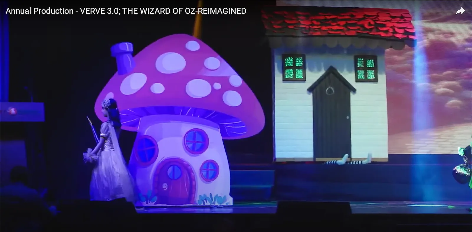 Mushroom house and cottage props on stage for The Wizard of Oz