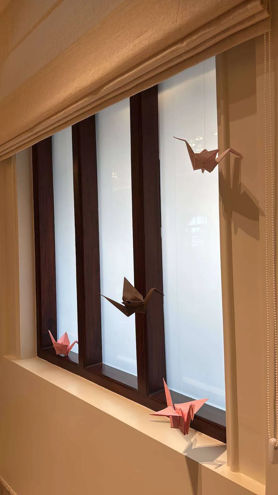 Paper cranes perched on a window sill
