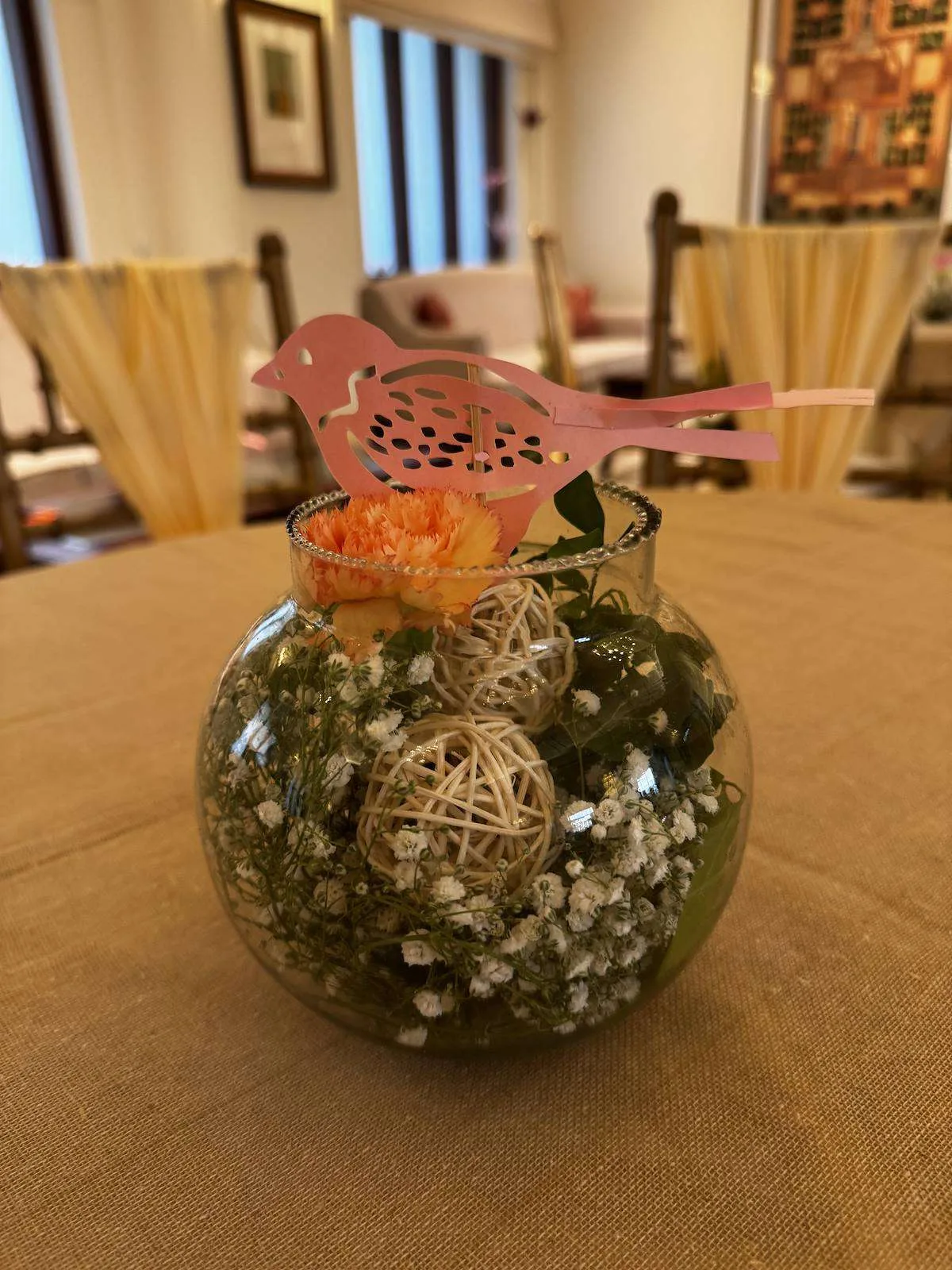 Pink paper bird centrepiece on a glass terrarium