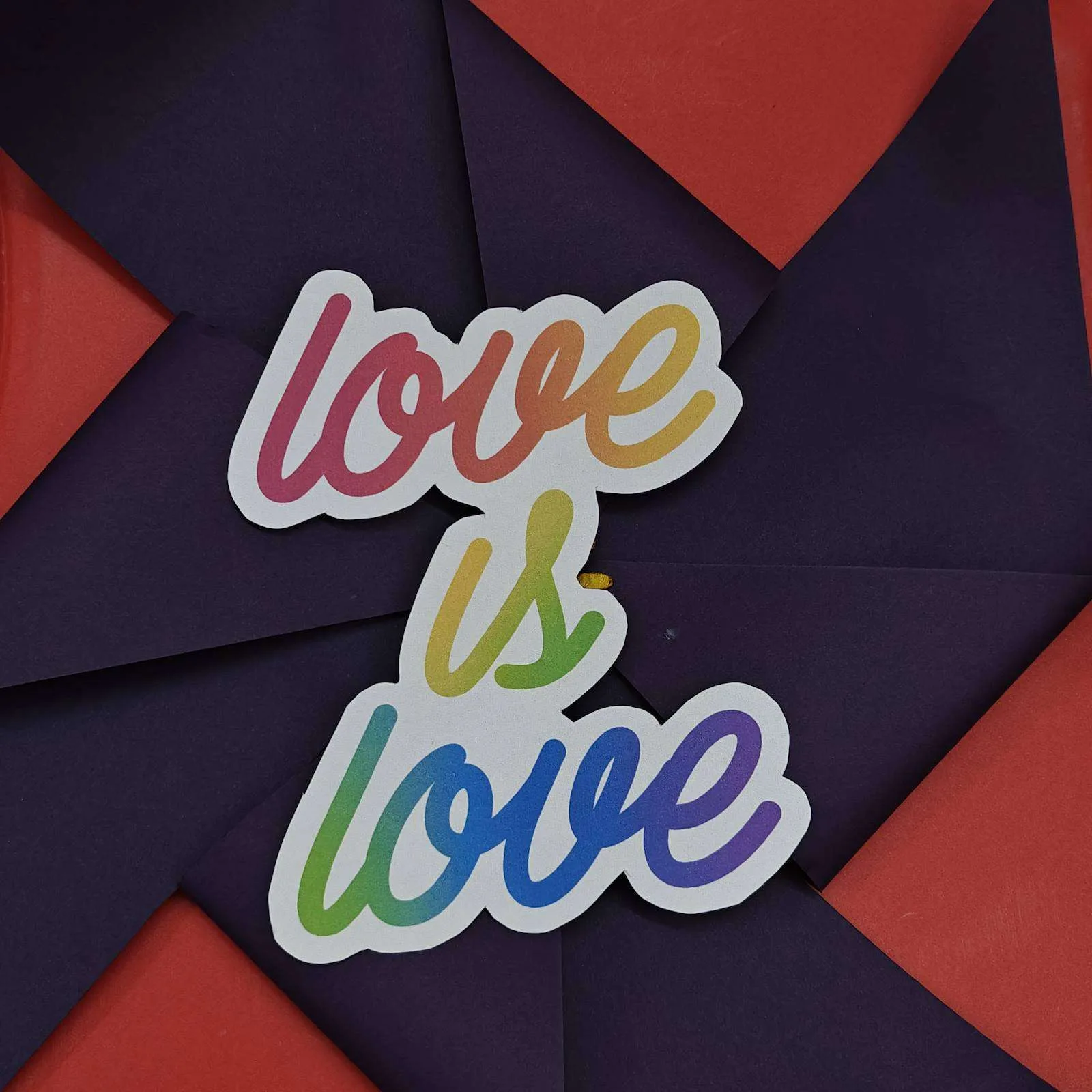 Love is love sticker on a red and purple pinwheel