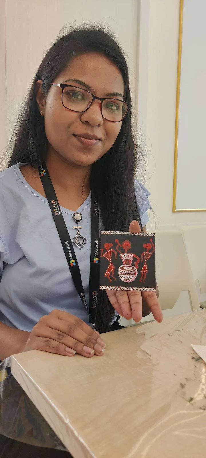 Participant holding her finished painted coaster