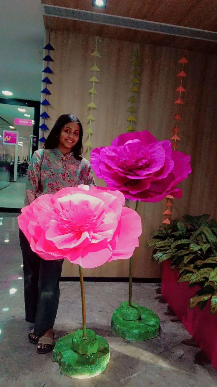 Giant pink paper flowers with a team member