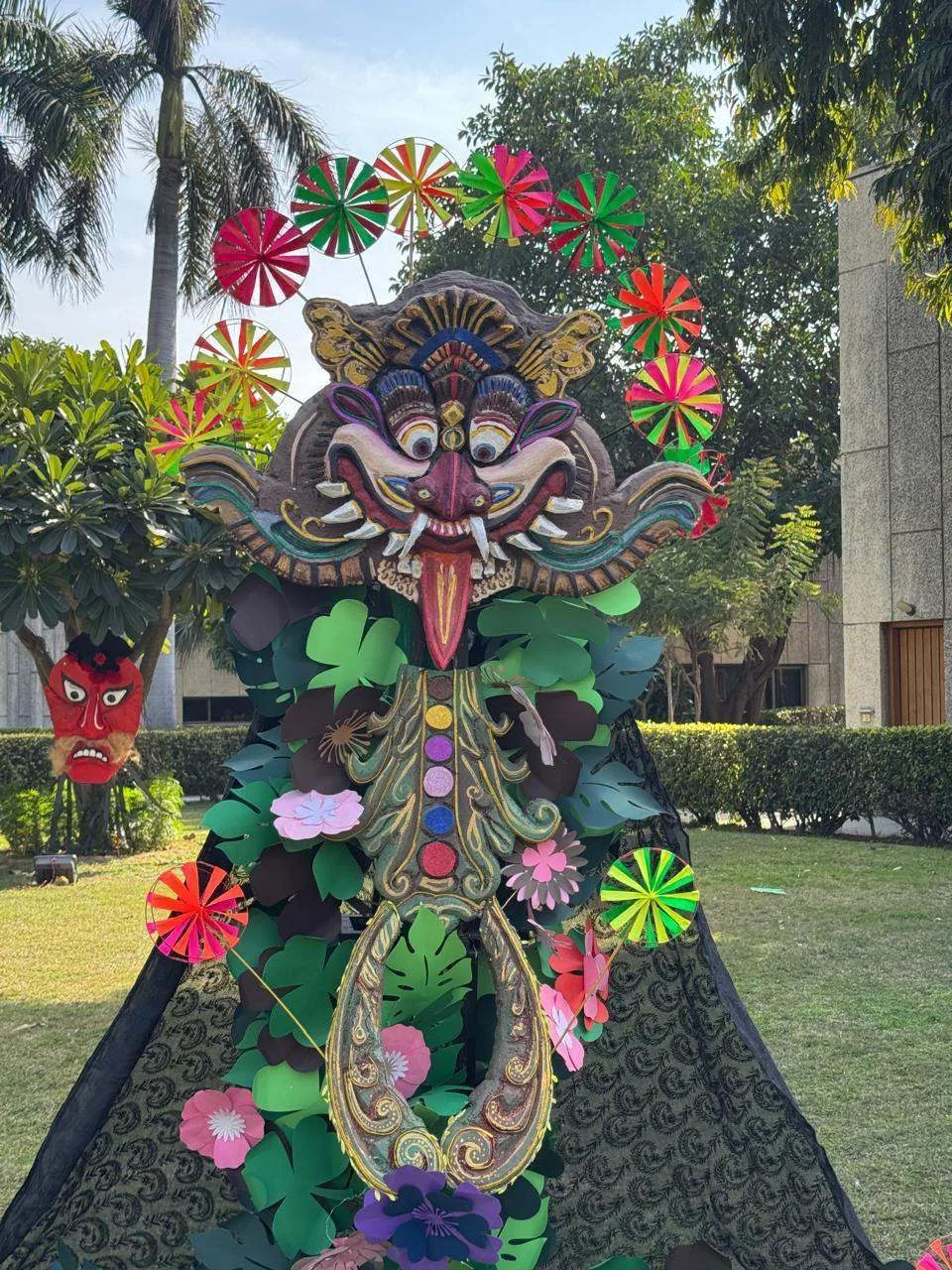 Kirtimukh paper sculpture on display in a garden
