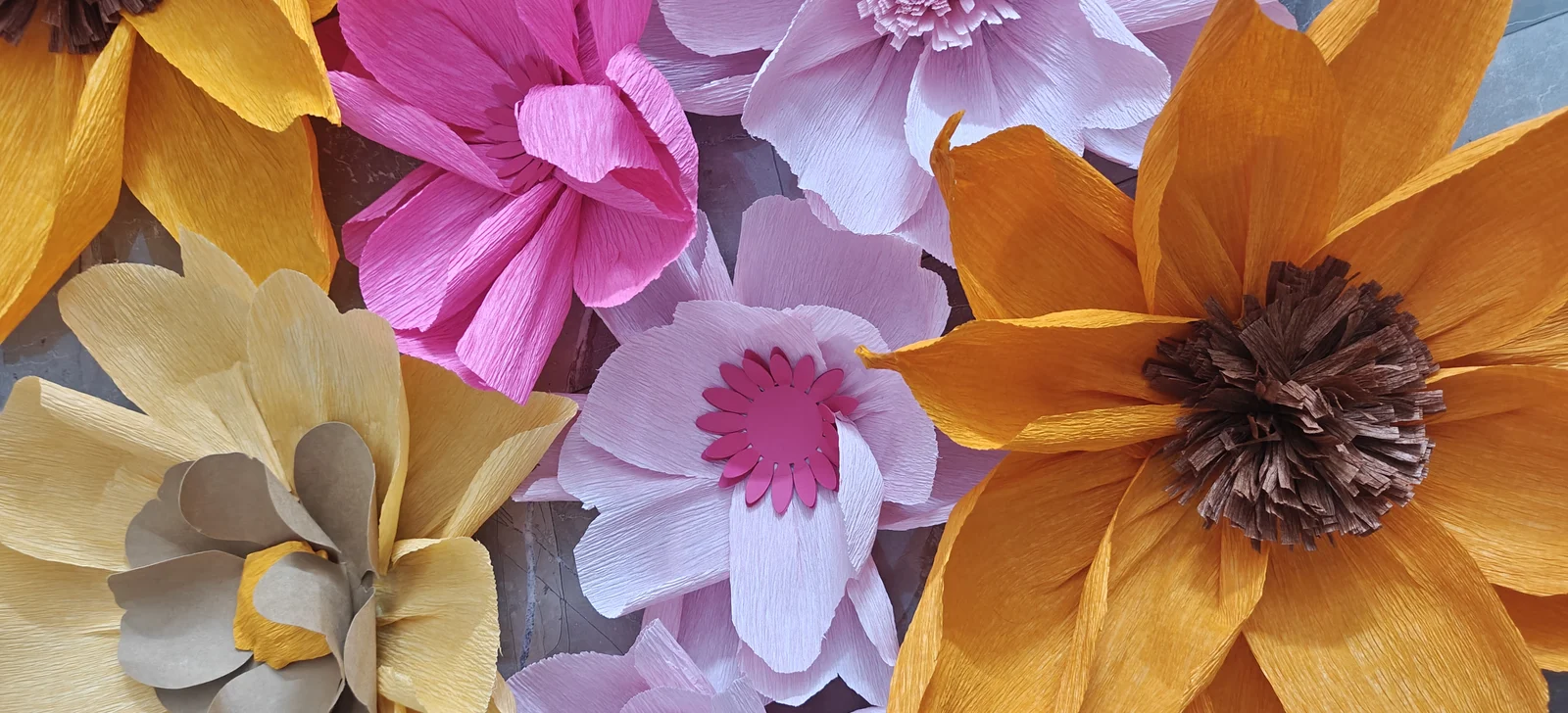 Giant handmade crepe paper flowers in pink, purple and orange