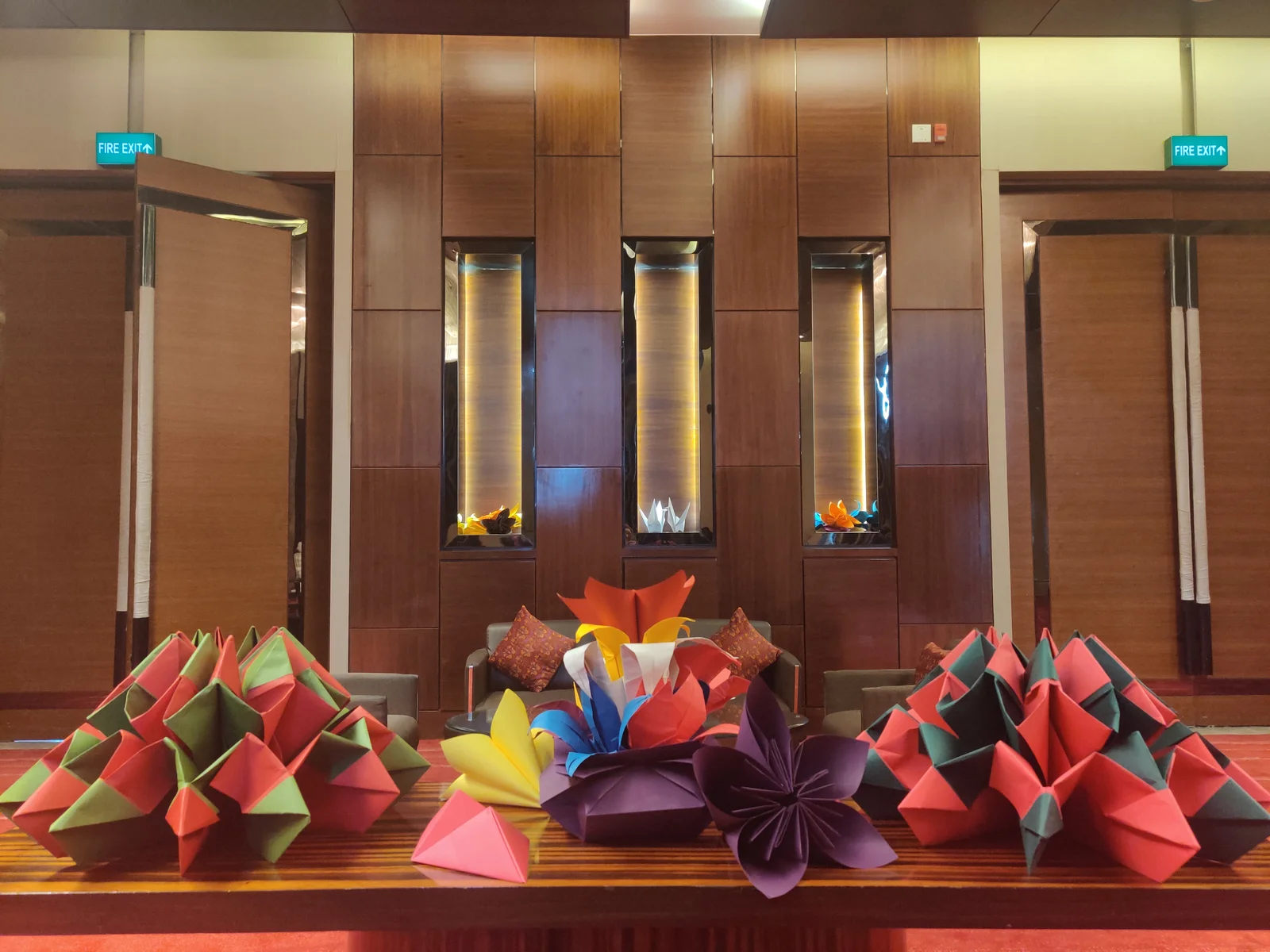 Colourful origami flower arrangement displayed in a hotel lobby