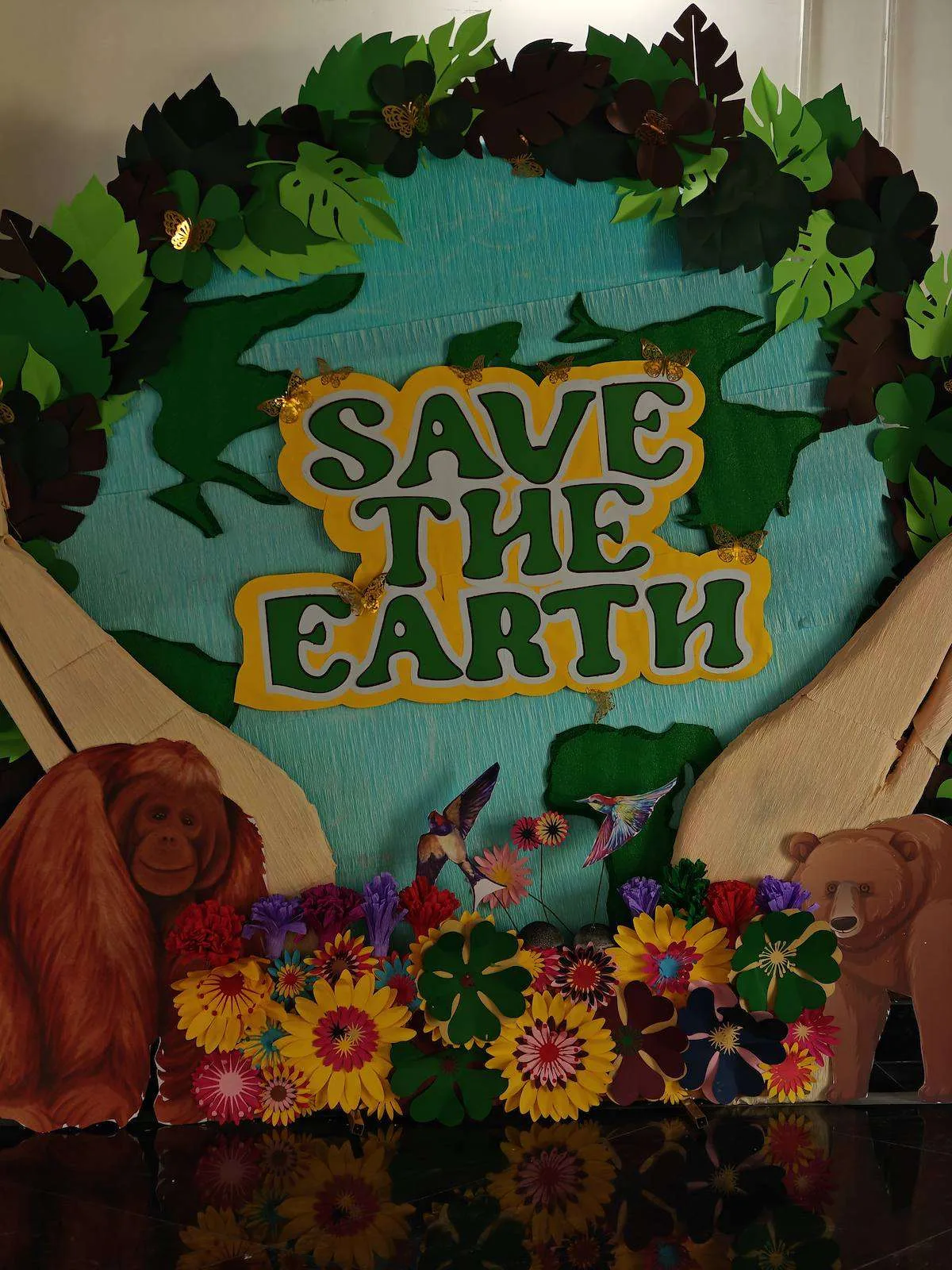 Save the Earth sign surrounded by paper flowers and animals