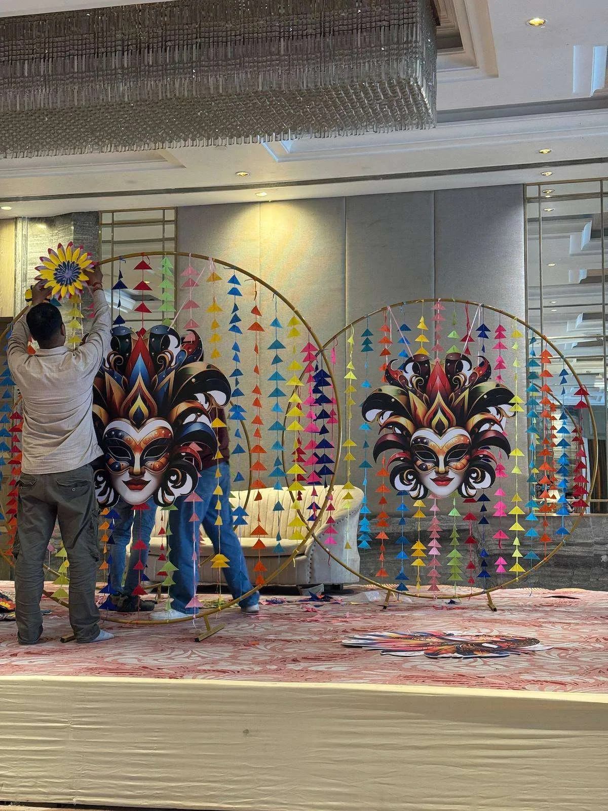 Team installing carnival paper mask arches